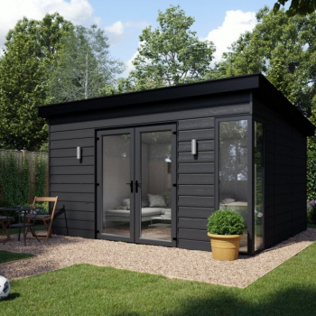 A black garden building on a patio surrounded by lawn space
