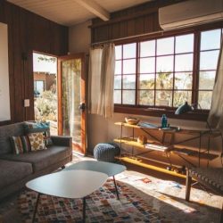 A beautiful, bright living room with large French windows, a sofa and a coffee table